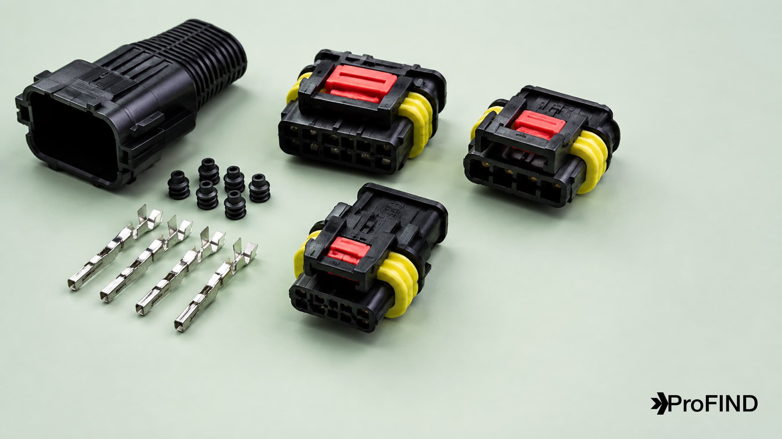 Black automotive connector housings with red locks, a yellow rear seal, contacts, and a backshell