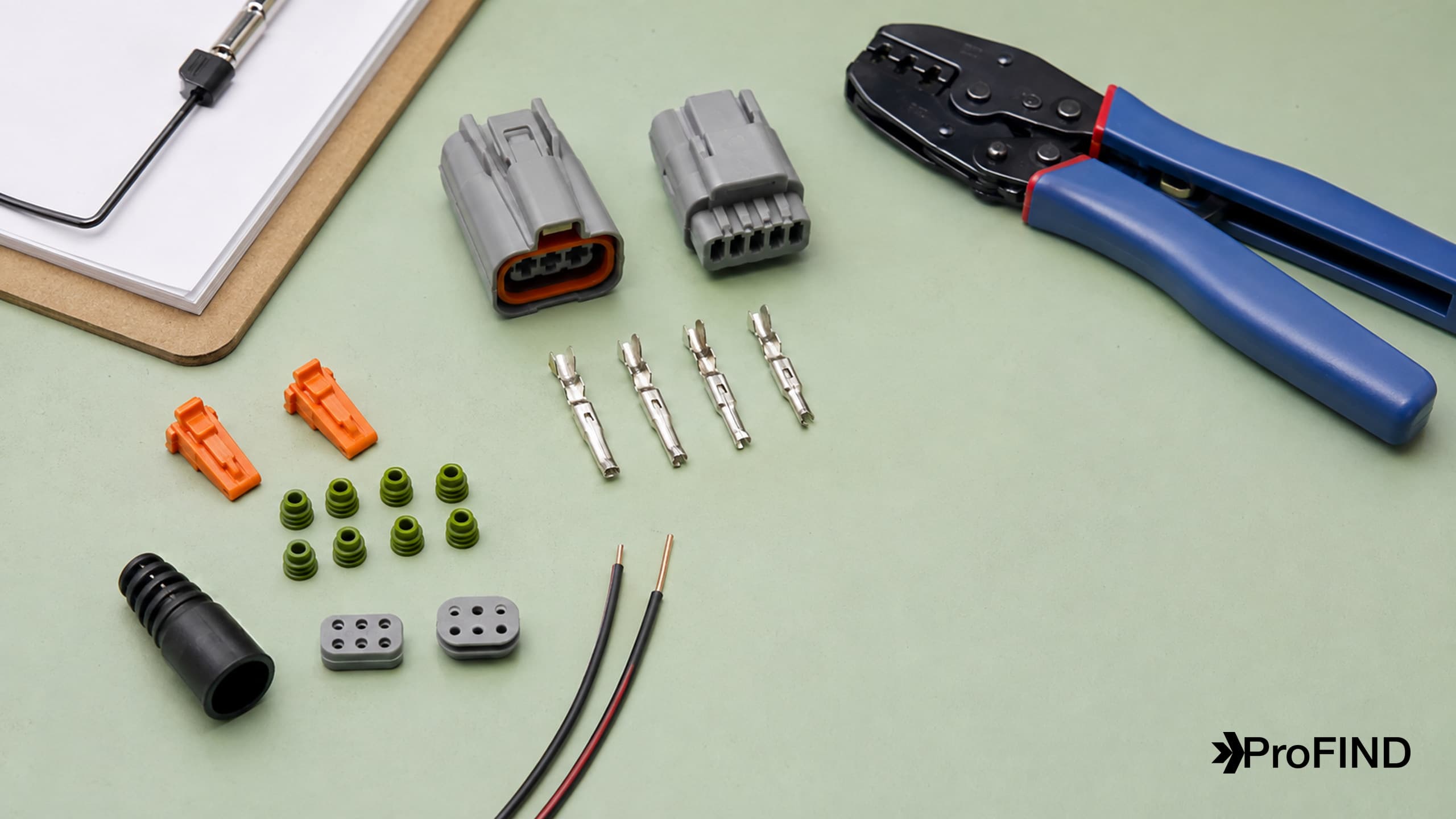 Connector housings, contacts, locks, seals, a boot, wires, and a crimp tool laid out for inventory