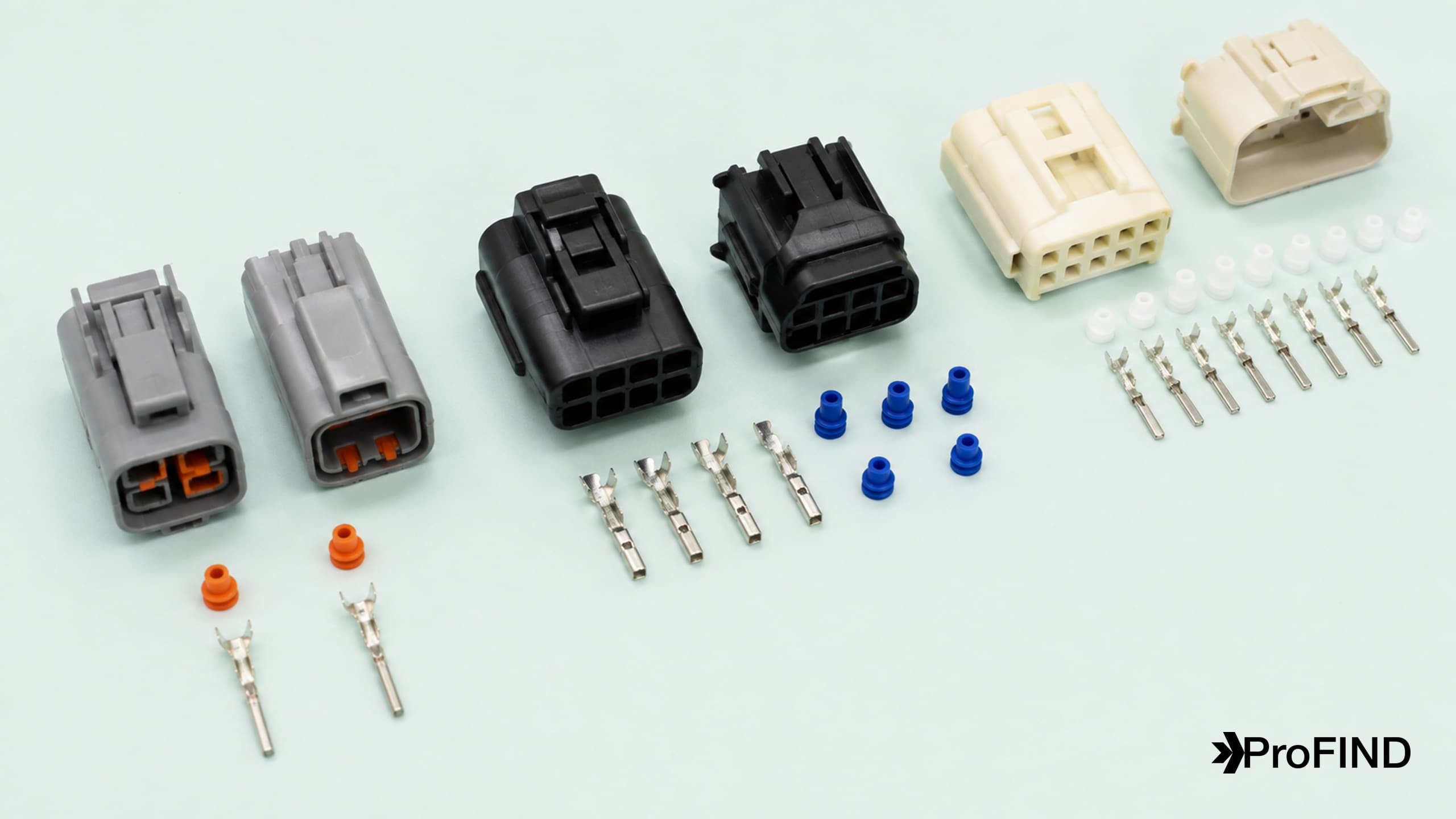 Three different connector pairs arranged with contacts and seals on a pale mint surface